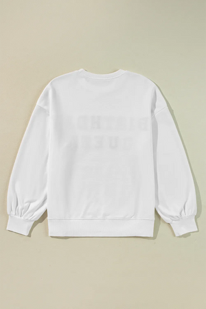 White sweatshirt with puff sleeves and "Birthday Queen" graphic