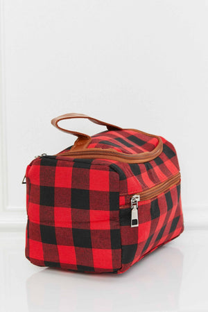 Red and black buffalo check travel case with brown faux leather handle and zipper.