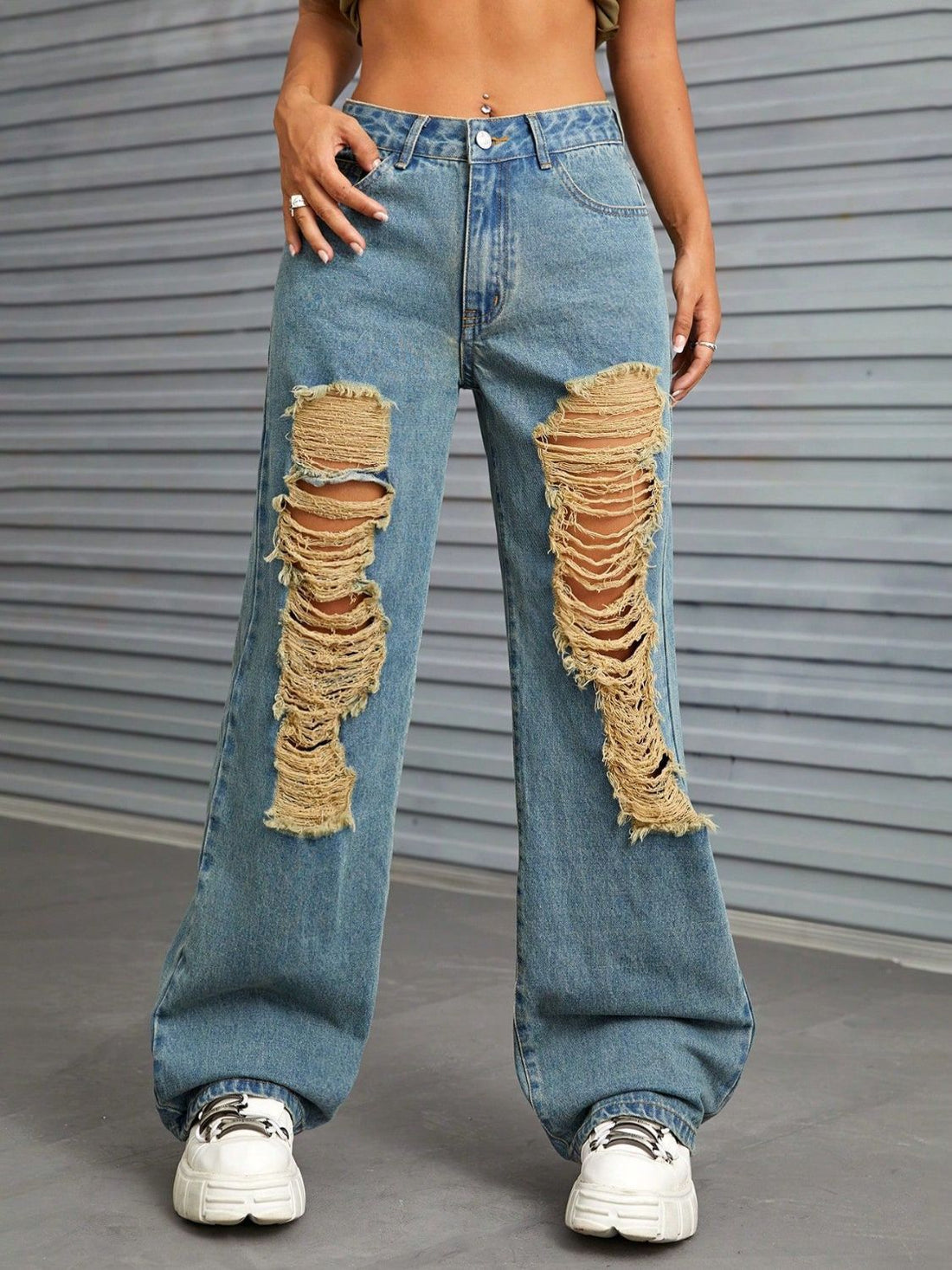 Medium wash distressed denim flare jeans with raw edge details and ripped knees.