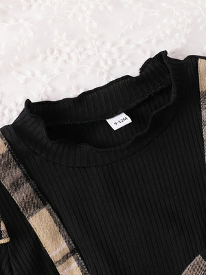 Black ribbed baby dress with ruffled neckline and plaid trim.