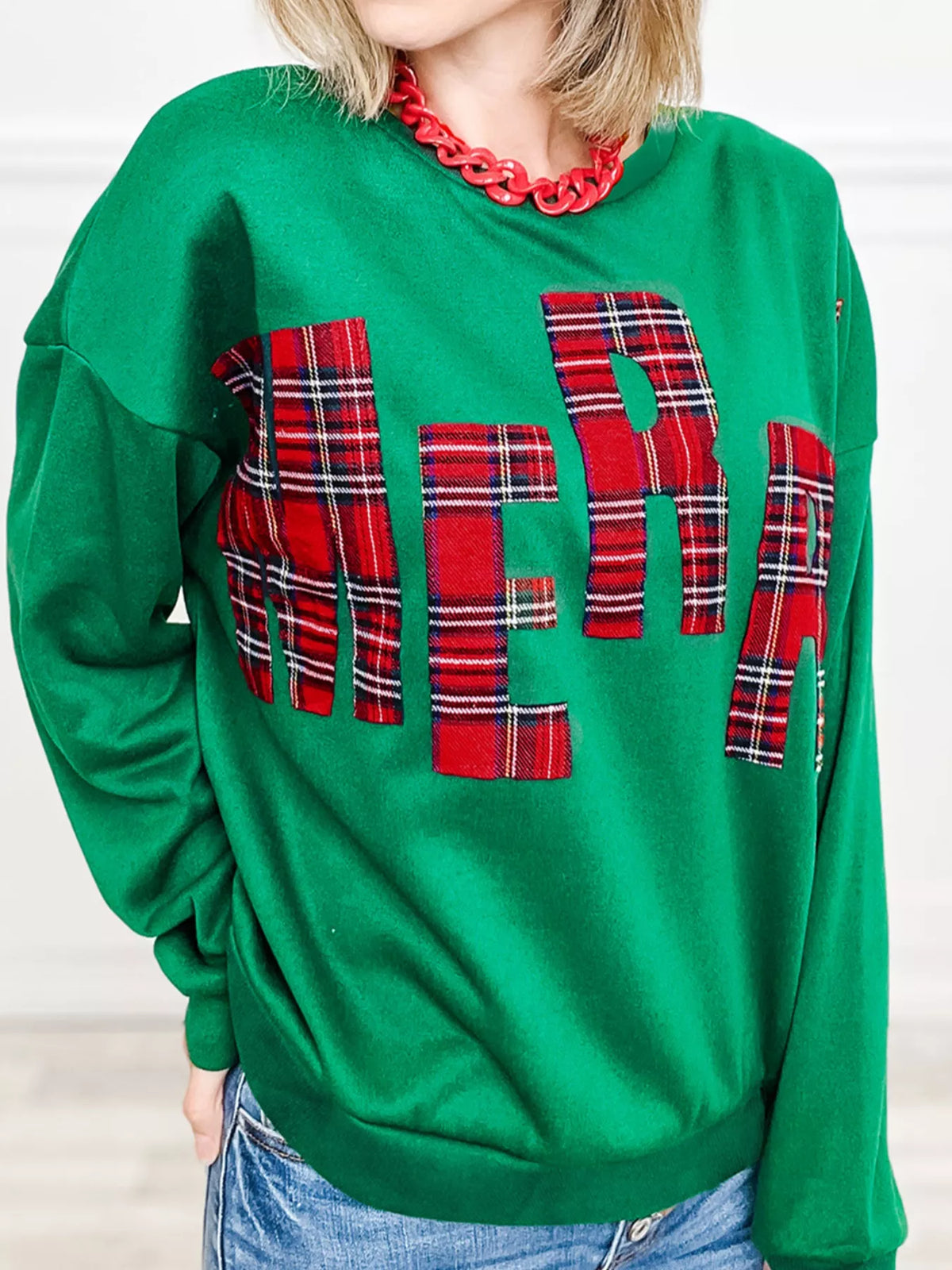 Green sweatshirt with plaid letter graphic and crew neck.