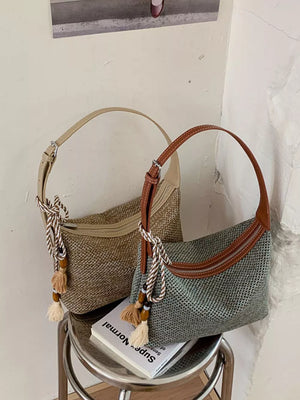 shoulder bag in beige featuring tassel detail and curved fit