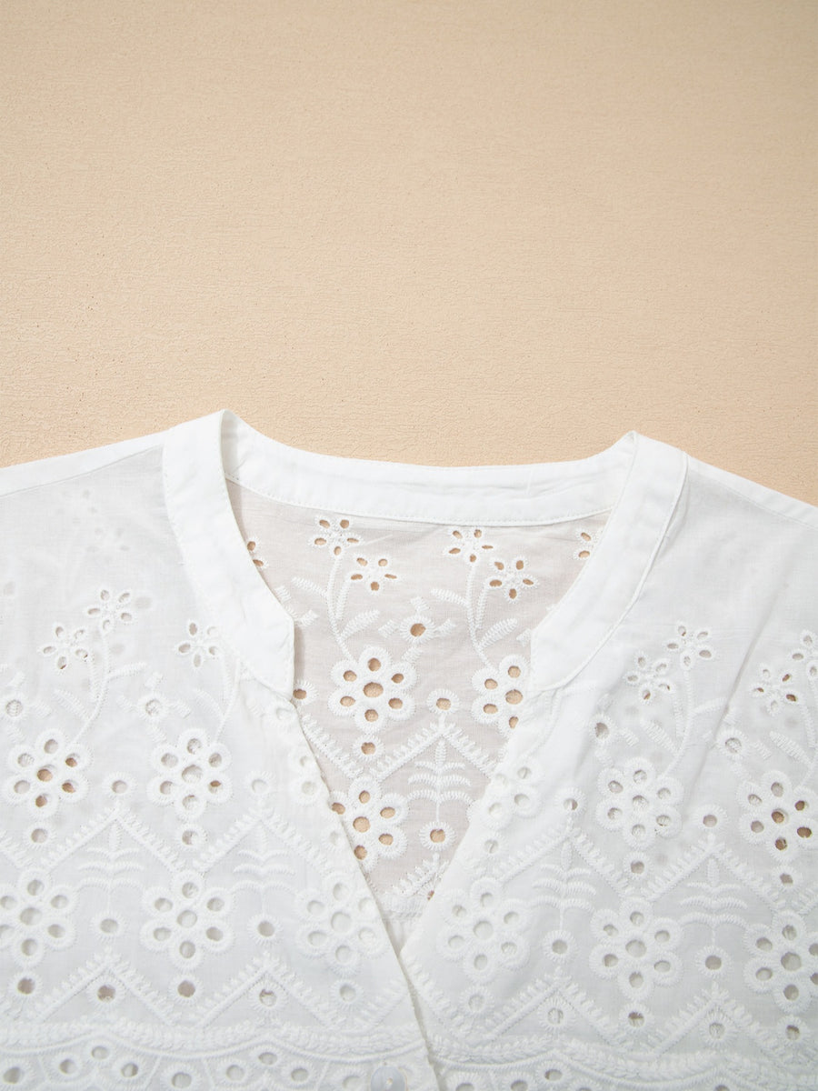 White cotton eyelet embroidered sheer shirt with floral details and a V-neck.