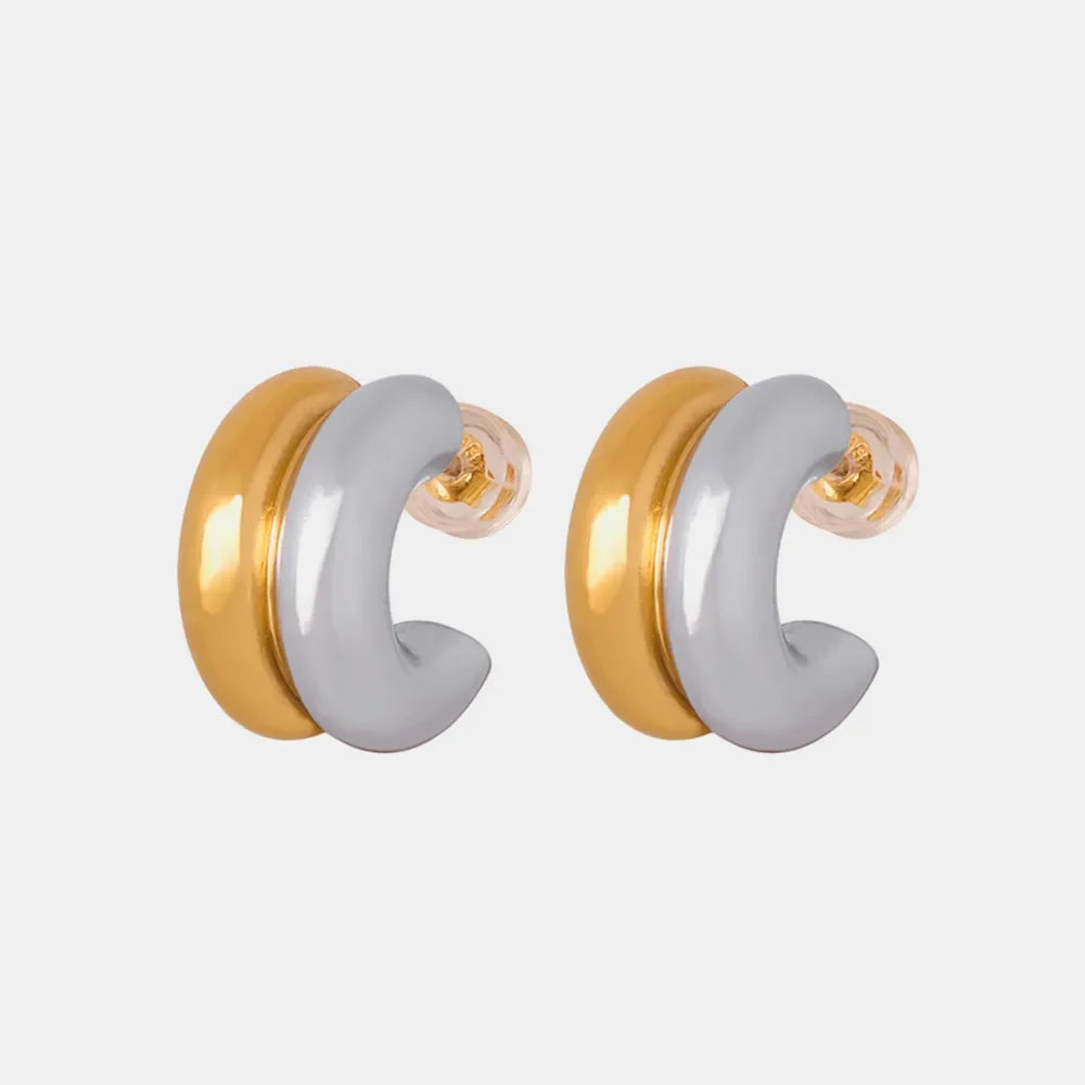 Dual-tone sculptural C-hoop earrings in gold and silver with a polished finish.