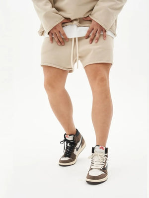 Beige fleece lounge shorts with raw hem and drawstring waist