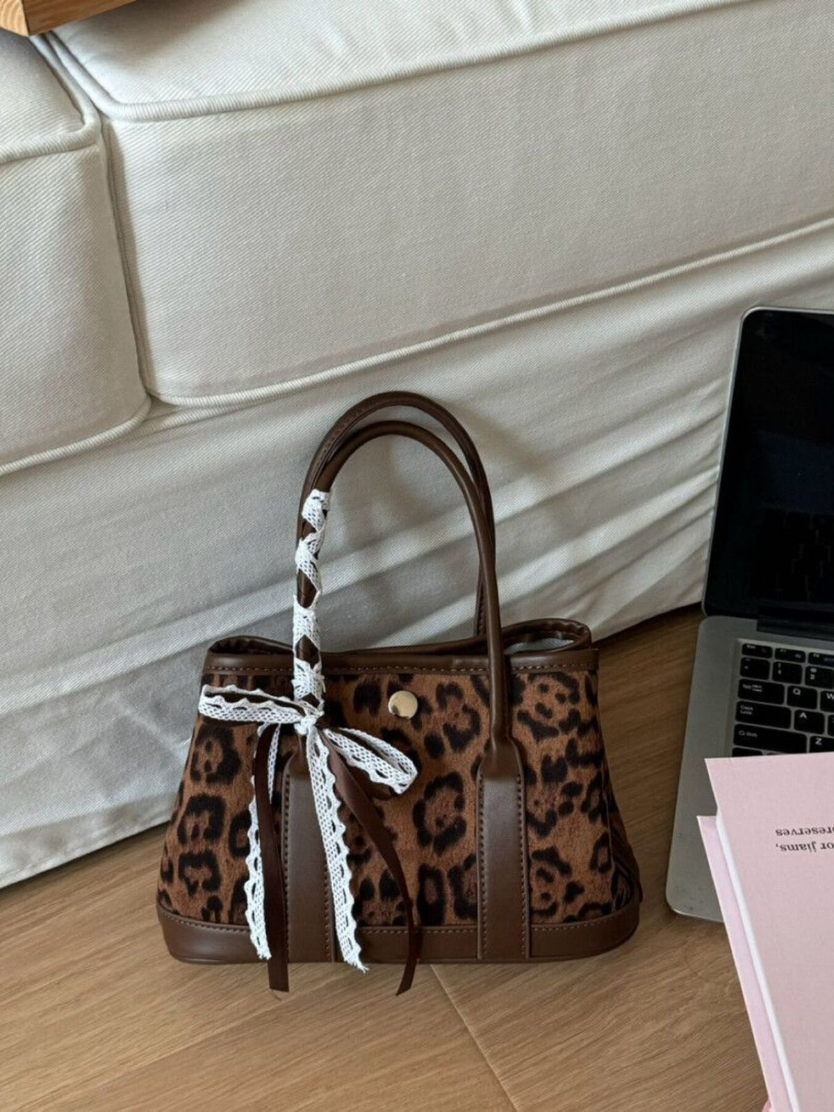 Leopard print tote bag with brown trim and lace-trimmed ribbon detail