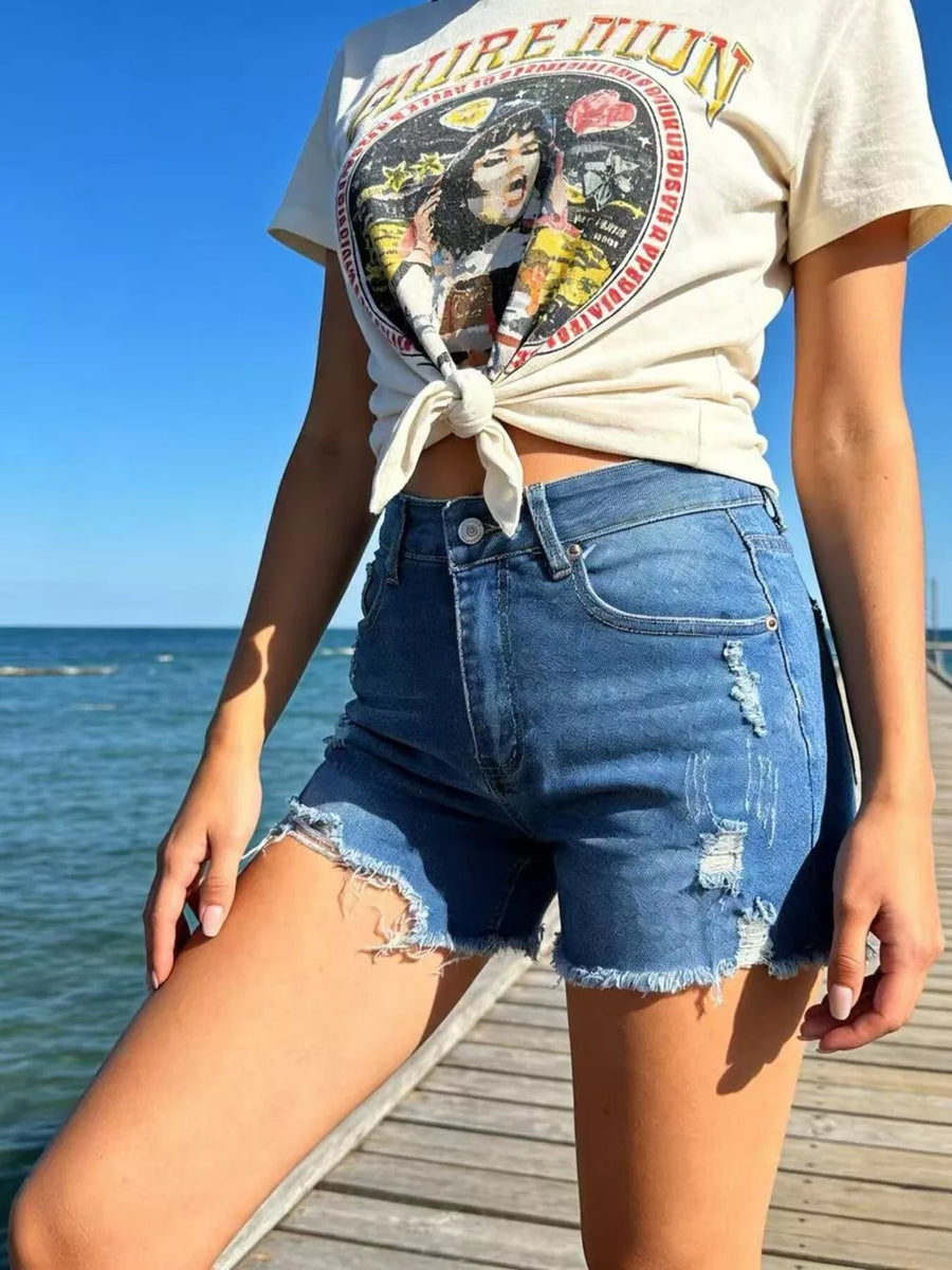 Distressed raw hem denim shorts in dark blue with button fly and frayed edges.