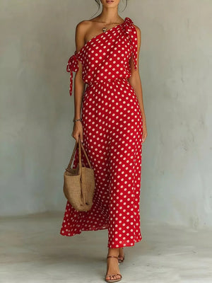 Red polka dot one-shoulder maxi dress with tie details and a cinched waist.