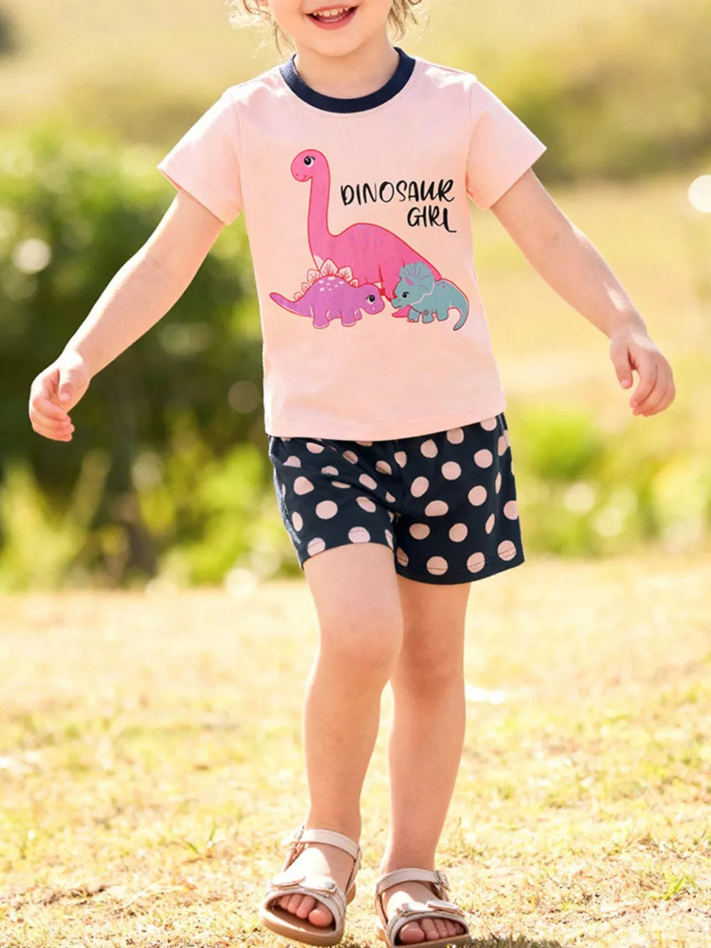 Baby girl's pink dinosaur graphic tee with navy polka dot shorts set
