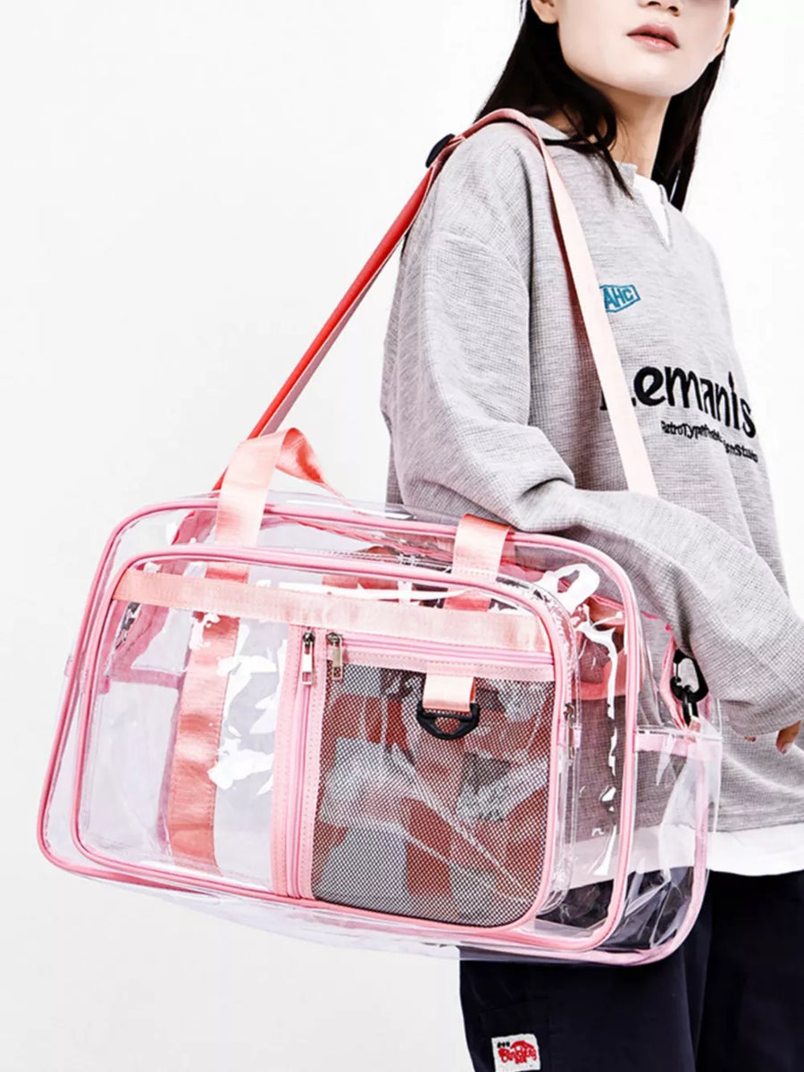 Clear duffel bag with pink trim and mesh pockets, worn by a model.