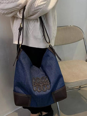 Blue denim shopper bag with brown leather trim and embroidered detail