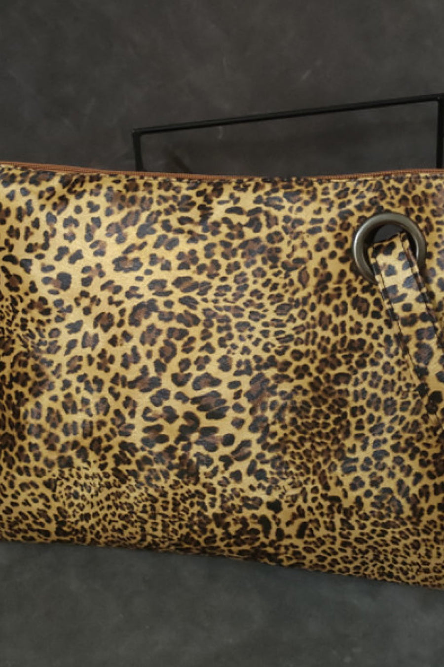 Leopard print clutch bag with zip top and metal grommet detail