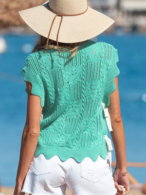 Pointelle knit sweater in mint green with cable details, scalloped hem, and tie sides.