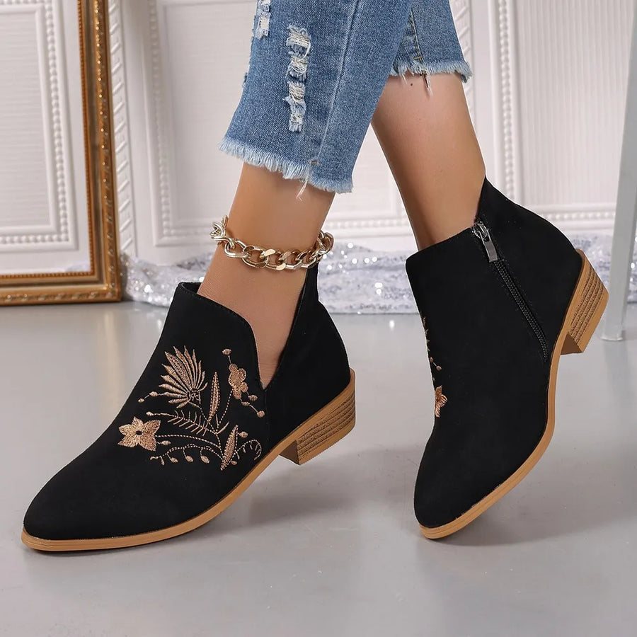 Black suede ankle boots with gold floral embroidery and side zip.