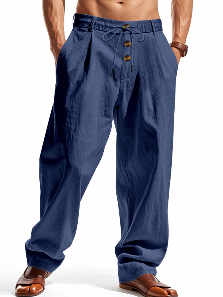 Men's navy blue drawstring loose fit pants with button detail and pleats.