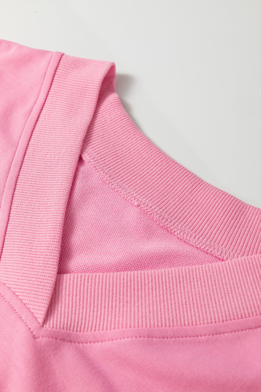 Pink cotton loungewear set with V-neck detail and ribbed trim.