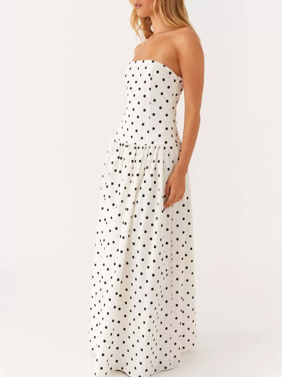 White polka dot strapless maxi dress with a tiered skirt.