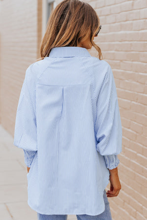 Pastel blue pinstripe blouse with balloon sleeves and smocked cuffs.