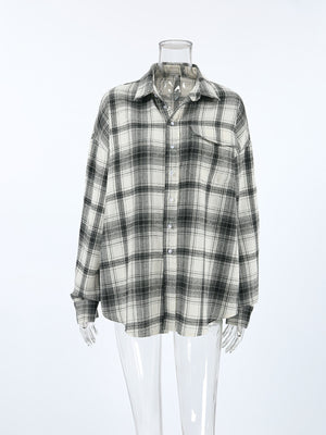 Button-up long sleeve cotton shirt in black and white plaid with a collar and chest pocket.