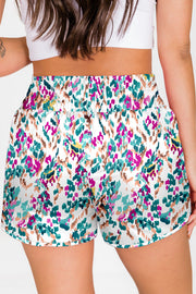 White running shorts with abstract brushstroke print and elastic waistband.