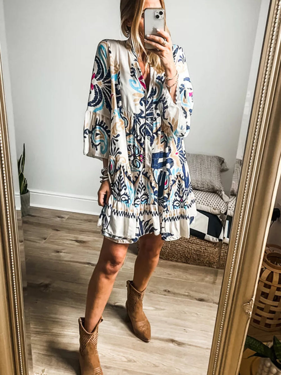 Vibrant abstract print tiered mini dress with button detail and collared neckline.