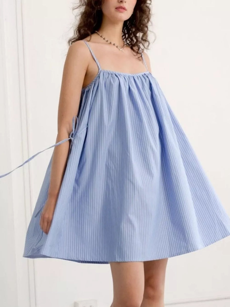 Blue and white striped cotton mini dress with spaghetti straps and tie details.