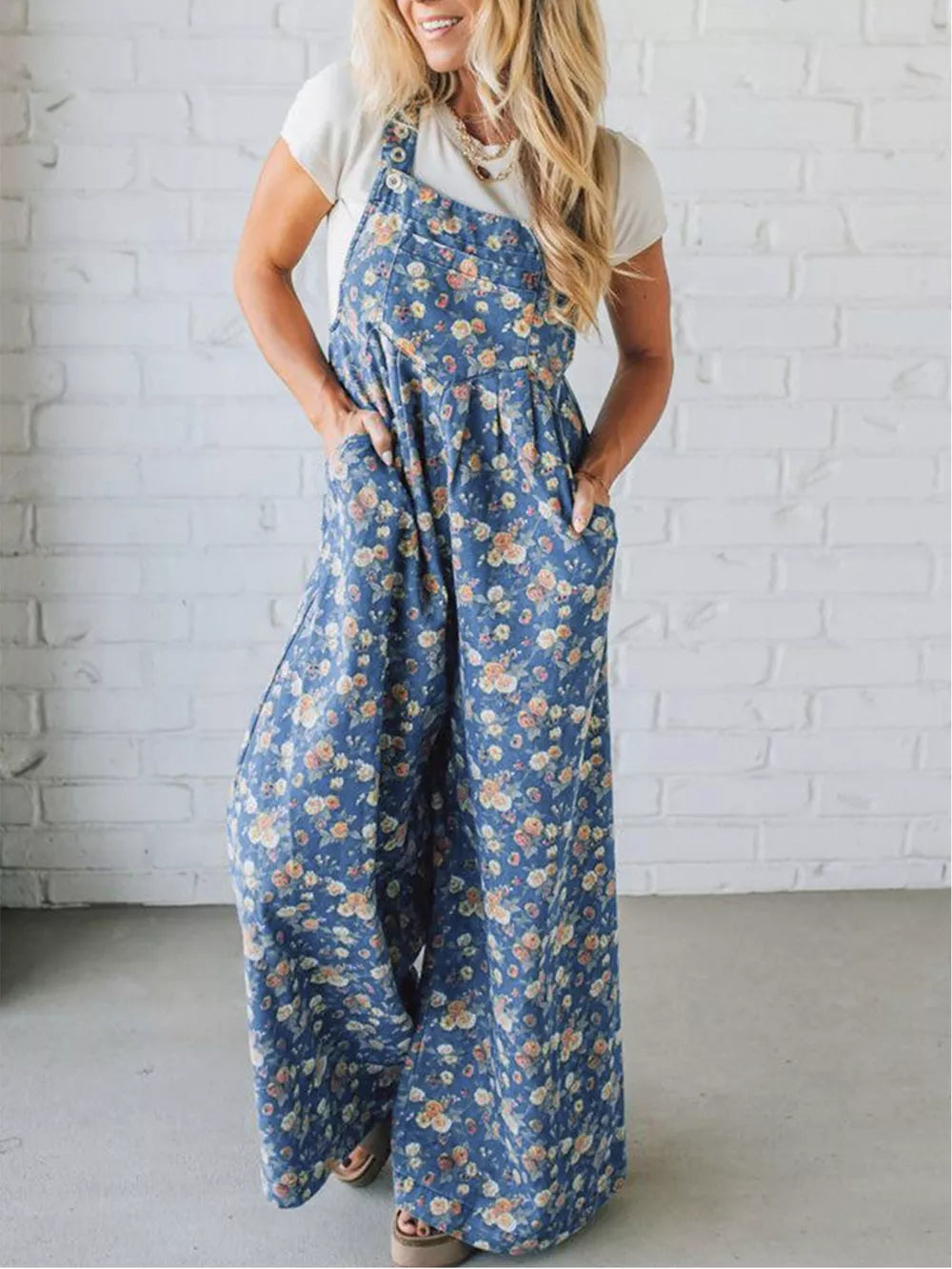 Floral denim overalls with wide legs and adjustable straps.