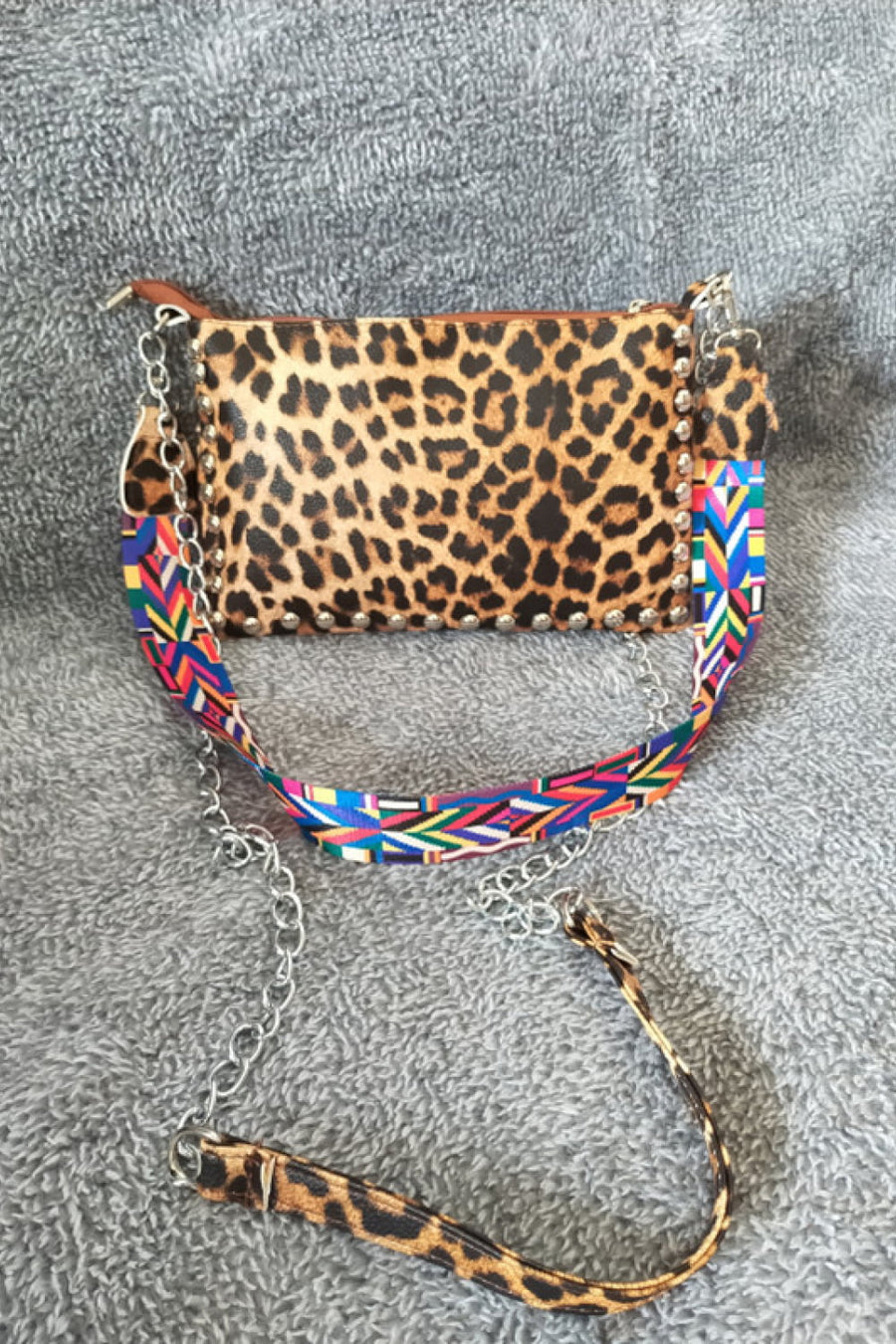 Leopard print shoulder bag with studded detail and colorful geometric strap