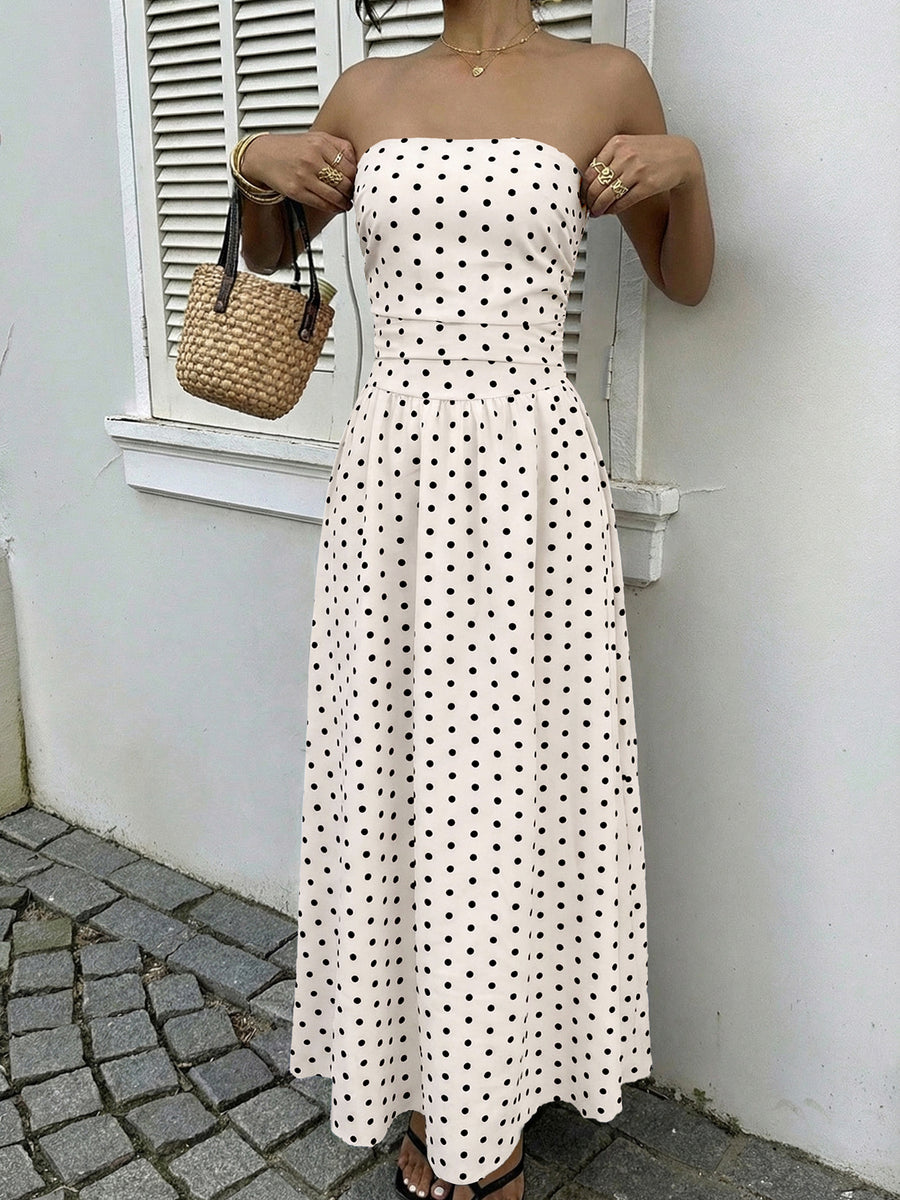 White polka dot A-line maxi dress with strapless neckline and belted waist.