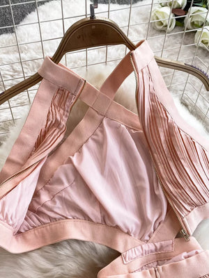 Pink pleated maxi dress with cutout detail and crisscross straps.
