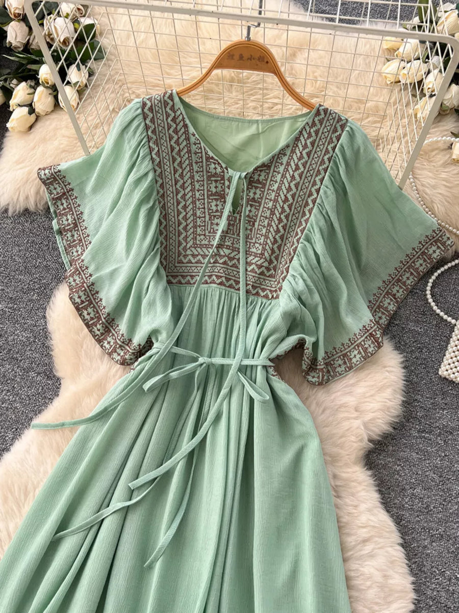 Mint green V-neck maxi dress with brown embroidery and tie waist.