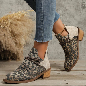 Leopard print ankle boots with cutout detail and a gold chain accent.
