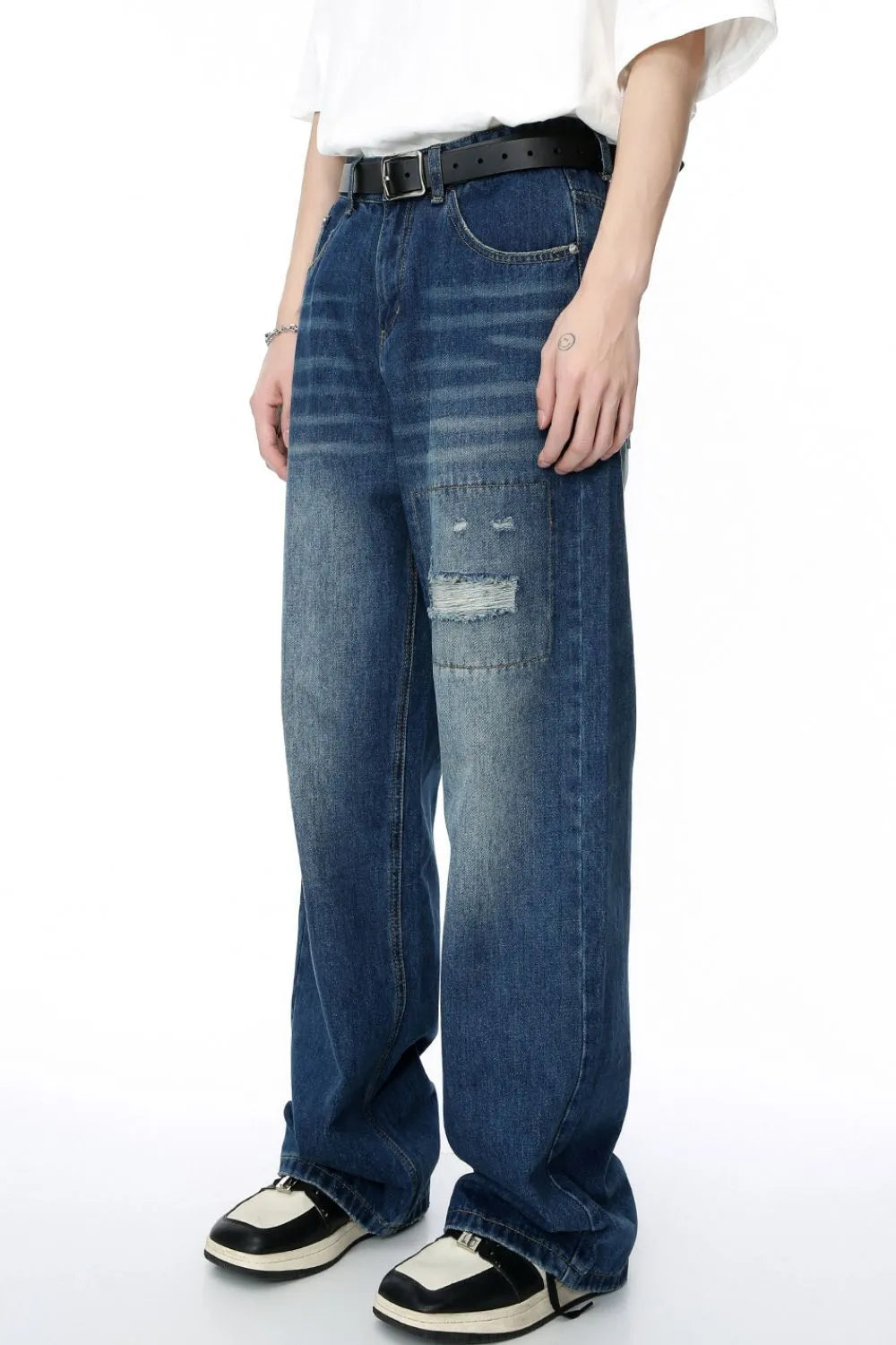 Baggy denim jeans in medium wash with patchwork and distressed details.