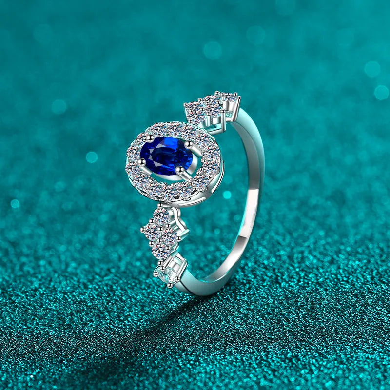 Silver ring with oval blue sapphire halo and diamond cluster accents