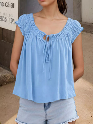 Blue gathered tie-front blouse with short sleeves and a scoop neckline.