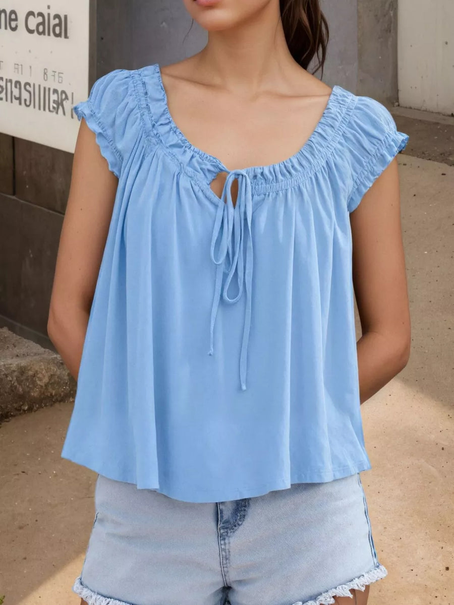 Blue gathered tie-front blouse with short sleeves and a scoop neckline.