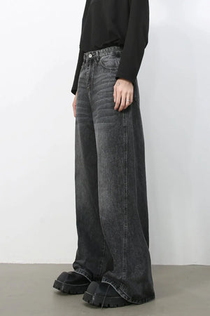 Dark wash denim trousers with exaggerated wide legs and a casual fit.