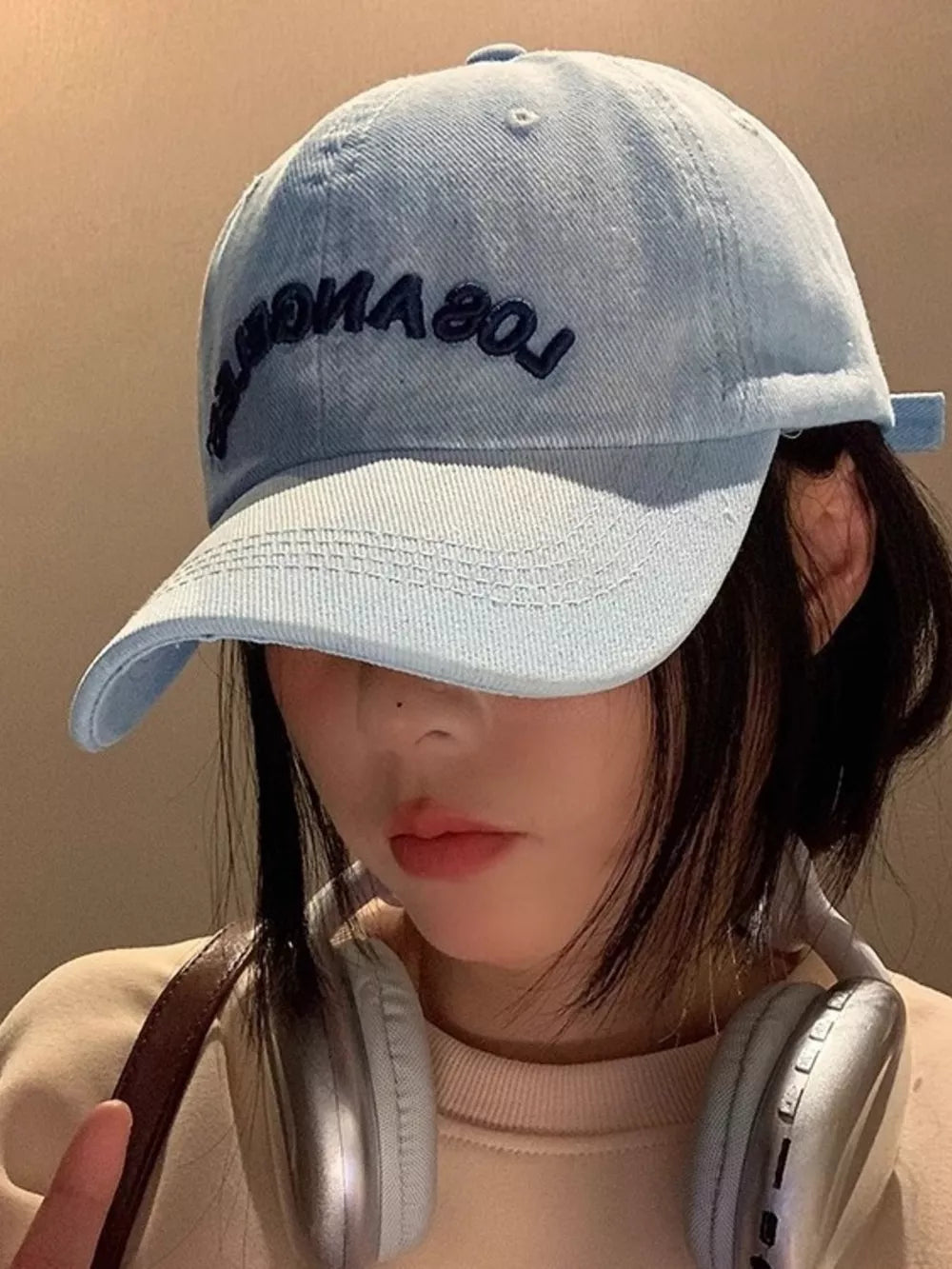 Light blue denim baseball cap with Los Angeles embroidery and adjustable strap.