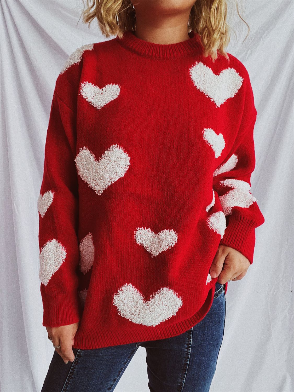 Red acrylic sweater with textured white heart appliqués and crew neck.