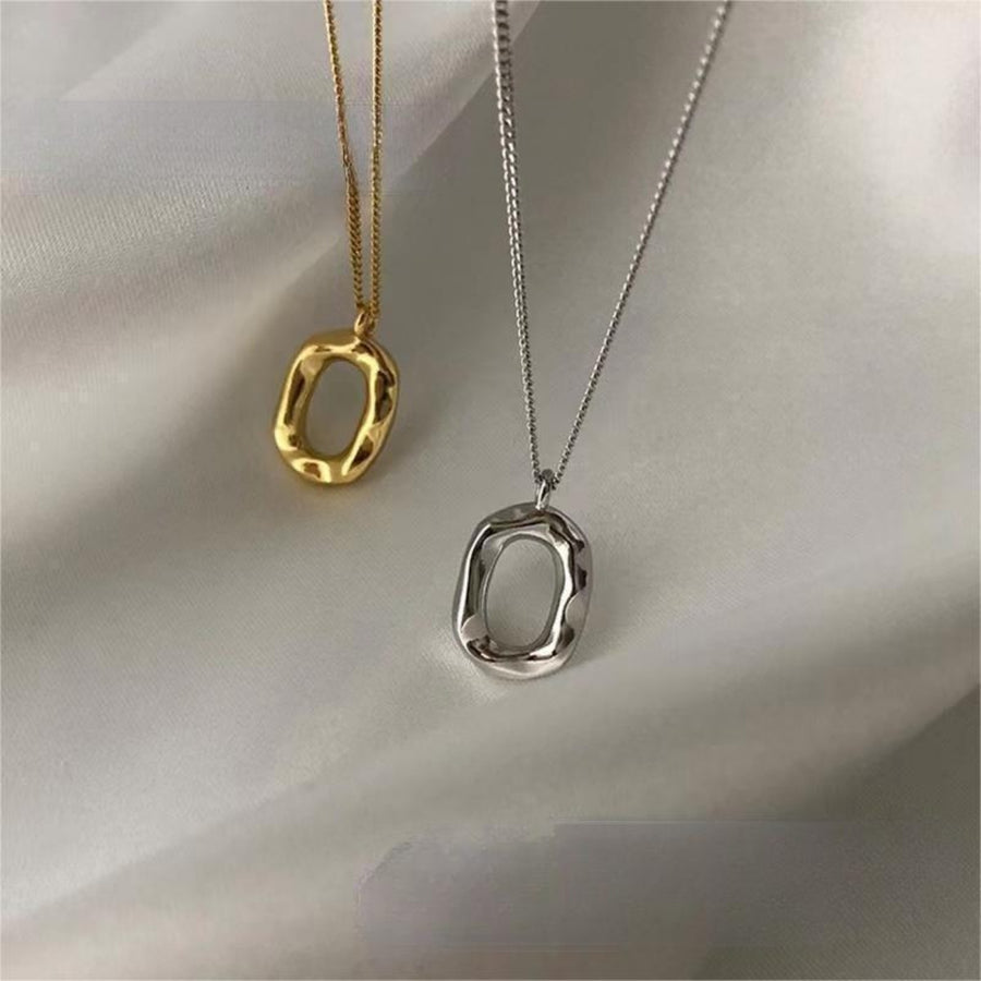 Geometric pendant necklaces in gold and silver with irregular oval shapes.