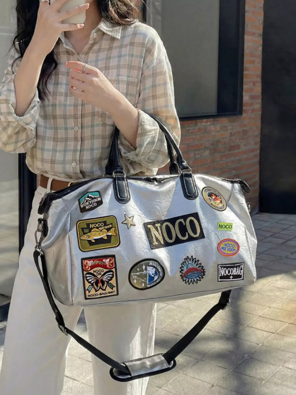 Metallic patchwork travel bag with textured finish and multiple embroidered patches.