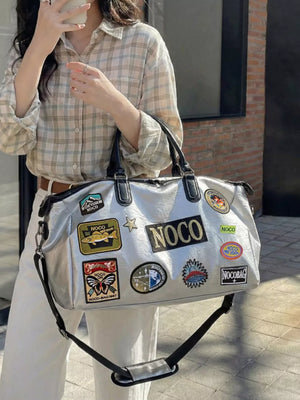 Metallic patchwork travel bag with textured finish and multiple embroidered patches.