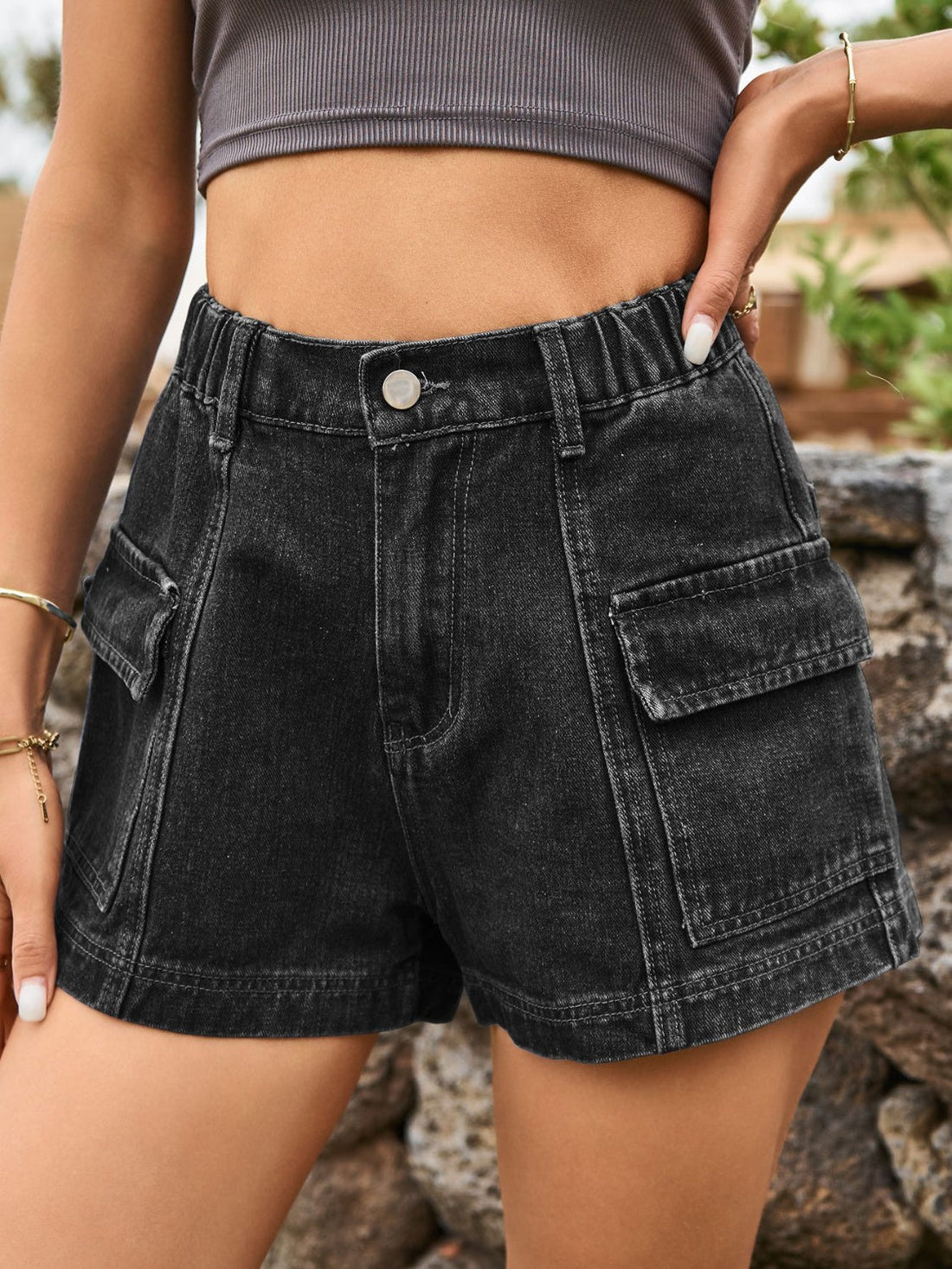 Black denim high-waist cargo shorts with elastic waistband and utility pockets.