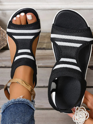 Black and white striped knit sport sandals with a white sole and black footbed.
