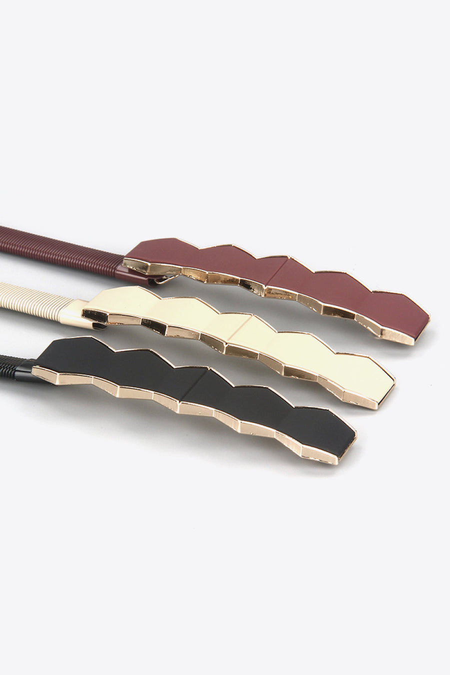 Geometric buckle waist belts in black, cream, and wine with gold trim.