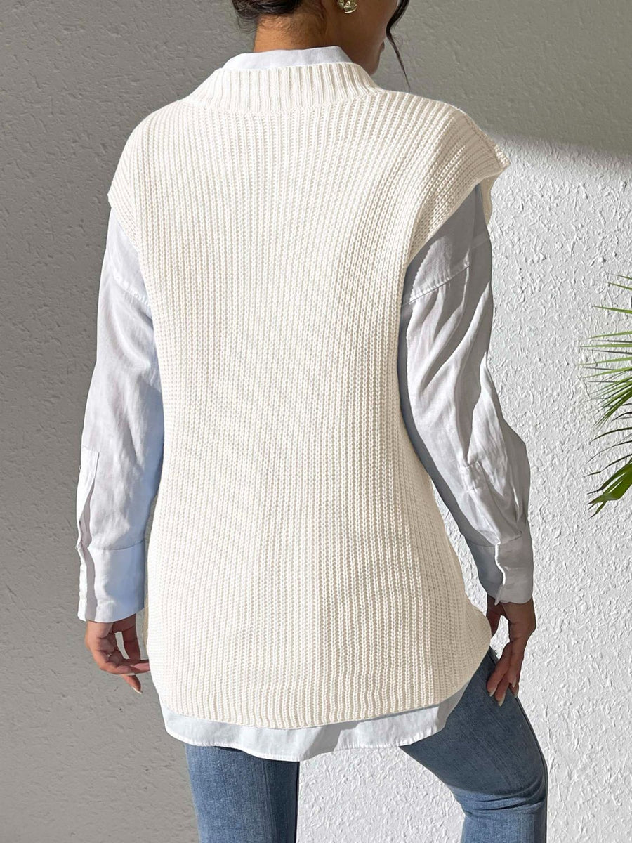 Ivory ribbed knit vest with mock neck, styled over a light blue button-down shirt.