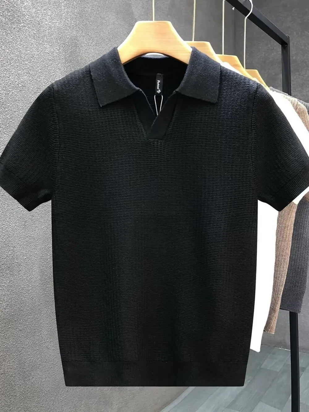 Black textured knit slim fit polo shirt with short sleeves and a V-neck collar.