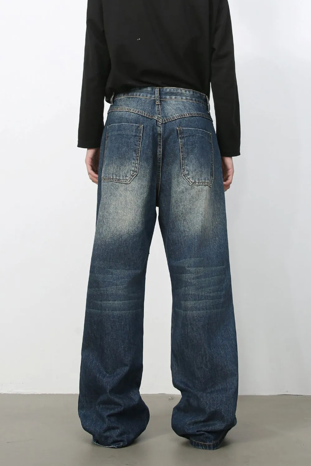 Medium wash distressed wide-leg jeans with a relaxed fit and visible back pockets.