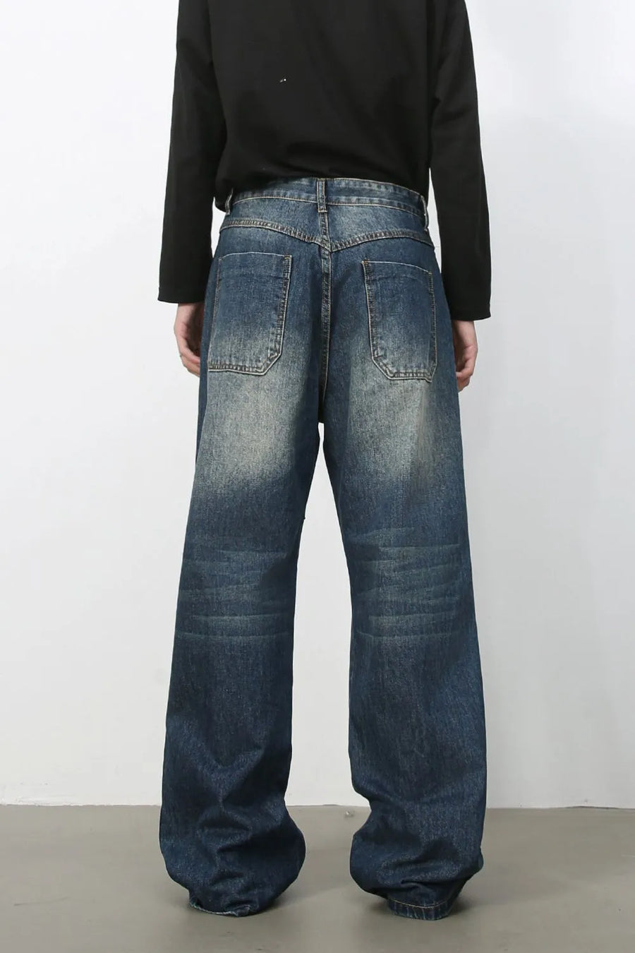 Medium wash distressed wide-leg jeans with a relaxed fit and visible back pockets.