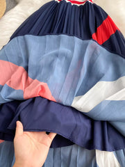 Chic pleated midi dress with color block design in navy, blue, red, white, and pink.
